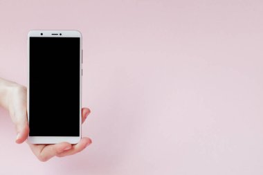 Pembe arka planda bir kadının elinde modern cep telefonu
