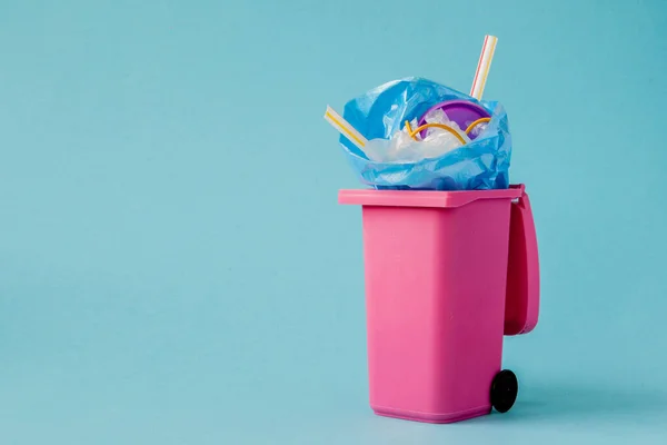 Studio shot van een roze grote prullenbak op blauwe achtergrond — Stockfoto