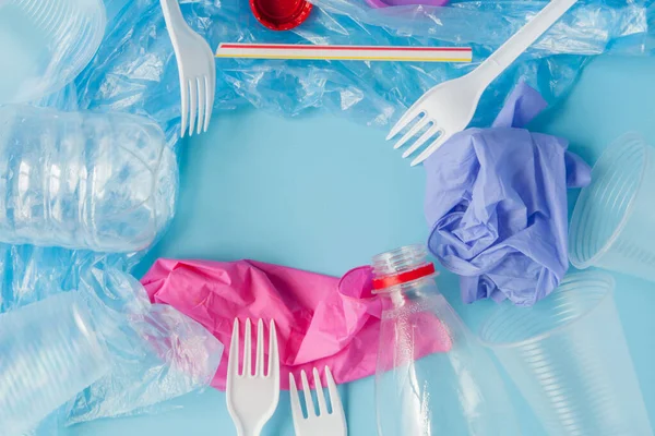 Bovenaanzicht van verschillende soorten wegwerp plastic afval op blauwe ba — Stockfoto