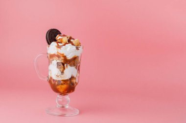 Pembe bsckground, seçici odak ve boş alan üzerinde bisküvi ve krem şanti ile cam tatlı tatlı