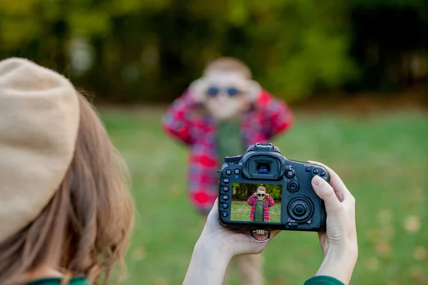 Női fotós fényképezés a gyermek tölteni kívül a parkban — Stock Fotó