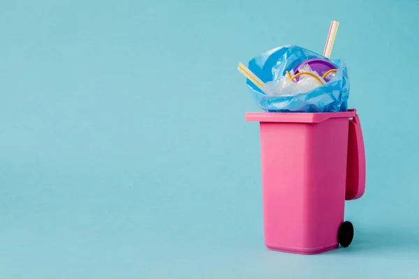 Estúdio tiro de um grande lixo rosa no fundo azul — Fotografia de Stock