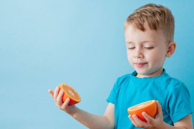 Little Boy mavi arka plan, di elinde bir Portakal Holding