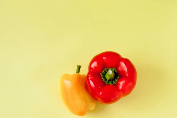 Intero di peperone dolce giallo e rosso o peperone su giallo — Foto Stock