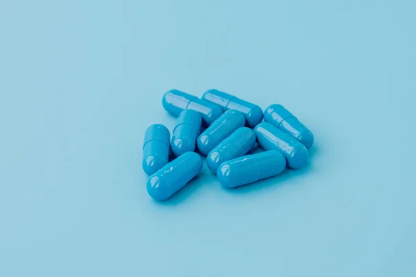 Голубые капсулы, таблетки на голубом фоне. Витамины, питательные вещества — стоковое фото