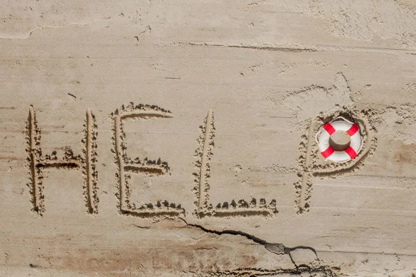 Help me the inscription and lifebuoy on the sand. Please help me. On a tropical beach