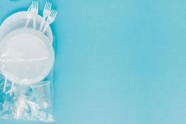 Mavi arka planda plastik tabaklar. Tek kullanımlık sofra takımları