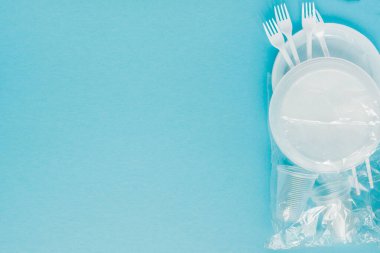 Mavi arka planda plastik tabaklar. Tek kullanımlık sofra takımları