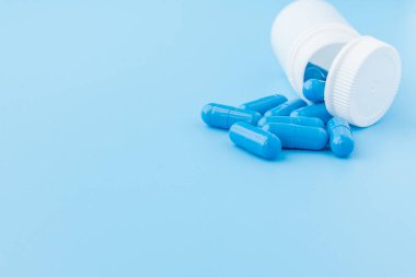 Mavi kapsüller, mavi arka planda haplar. Beyaz j içinde kapsüller