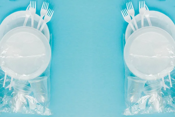 Plastic dishes on a blue background. Disposable tableware