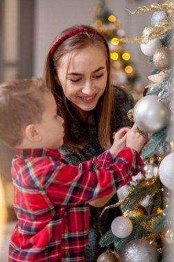 Anne ve oğlu Noel için dekore edilmiş ev altındadır. Aile mucize zamanı. Mutlu Noeller ve mutlu yeni yıl