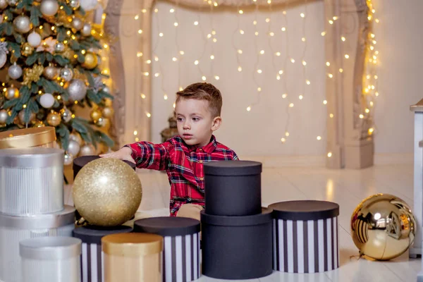 Férias e apresenta o conceito - menino feliz que põe no chão com presentes de Natal no quarto decorado — Fotografia de Stock