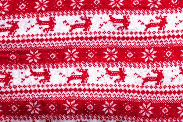 Echter roter Strickhintergrund mit weißem Weihnachtshirsch und Schneeflocken — Stockfoto