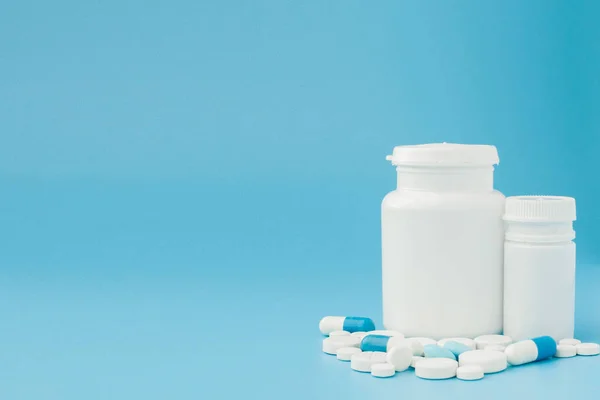 Sortierte pharmazeutische Medikamententabletten, Tabletten und Kapseln und Flasche auf blauem Hintergrund. Kopierraum für Text — Stockfoto