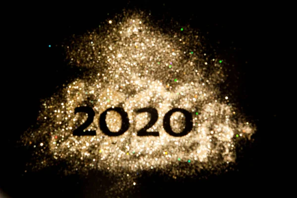 Happy New Year 2020. Creative Collage of numbers two and zero made up the year 2020. Beautiful sparkling Golden number 2020 on black background for design.