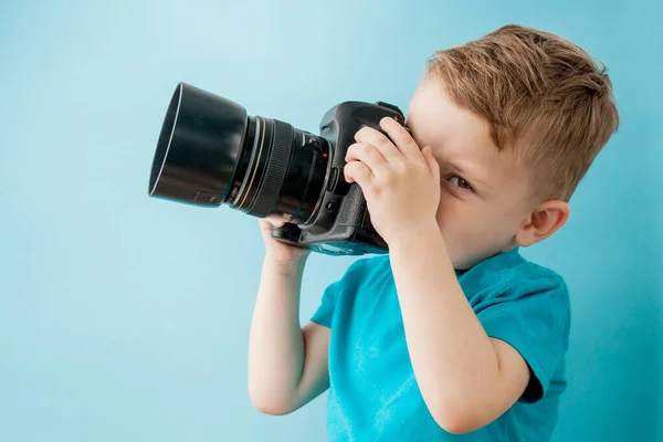 Kisfiú fényképezőgéppel a kék háttér — Stock Fotó