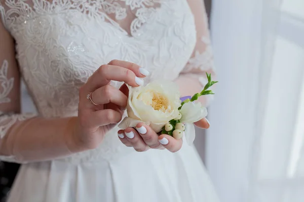 Close-up das mãos da noiva segura um boutonniere. boutonniere com rosa vermelha — Fotografia de Stock
