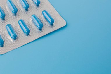Mavi kapsüller, mavi arka planda haplar. Vitaminler, besin değeri