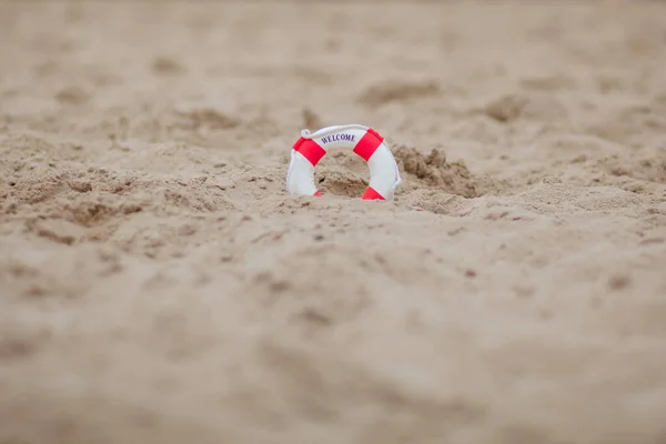 Primer plano de boya salvavidas en miniatura excavado en la arena en la playa — Foto de Stock