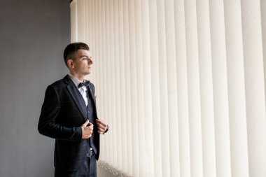 Adam iş gömleğini ilikleyerek işe hazırlanıyor. Damadın düğünden önceki sabah hazırlığı.