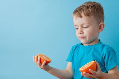 Little Boy mavi arka plan, di elinde bir Portakal Holding