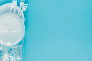 Mavi arka planda plastik tabaklar. Tek kullanımlık sofra takımları