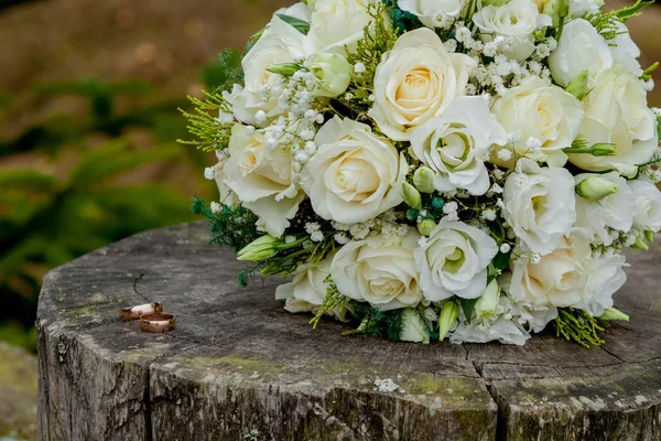 Düğün yüzükleri ve gelin buketi kütüğün üzerinde, gelin buketi.