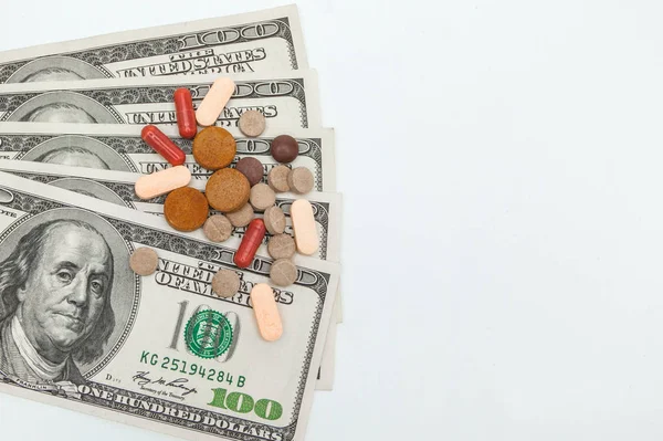 Píldoras medicinales de color y dólares americanos en blanco un backgrou — Foto de Stock