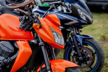 Motosikletlerin otoparkına yakın motosikletler park etmiş.