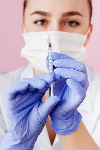Close-up van de verpleegkundige met een spuit voor injectie, op roze achtergrond — Stockfoto