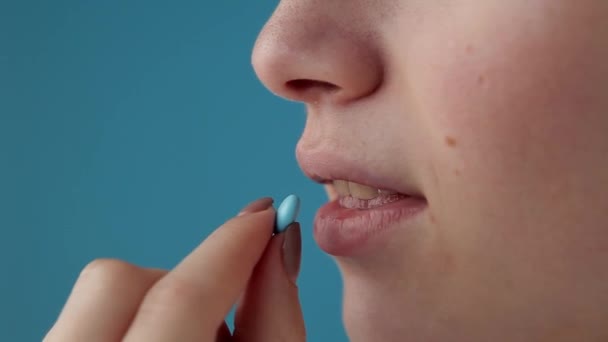 Vidám Vitamintablettát Szed Vizet Iszik Üvegből Kék Alapon Női Egészségügy — Stock videók
