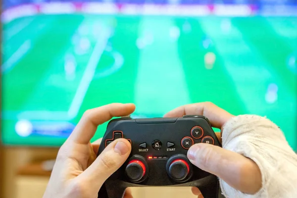 La mano rotta di un ragazzo tiene in mano un gamepad. Gioco di gioco giocare tv divertente giocatore gamepad ragazzo controller console video giocare giocatore in possesso di hobby giocoso godimento vista concetto - stock immagine — Foto Stock