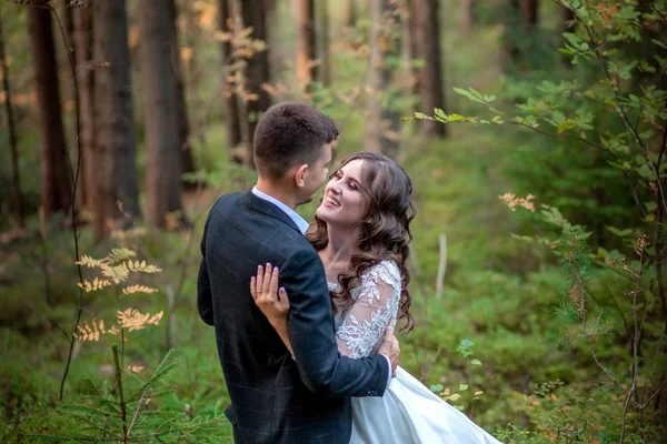 Menyasszony és vőlegény az erdőben az esküvőjükön, fotózás. — Stock Fotó