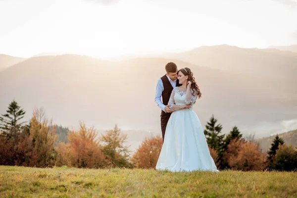 Braut und Bräutigam bei Sonnenuntergang romantisches Ehepaar — Stockfoto