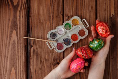 Kadının el ahşap arka plan üstünde Paskalya yumurta boyama Close-Up