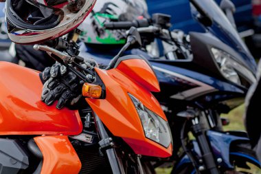 Motosikletlerin otoparkına yakın motosikletler park etmiş.