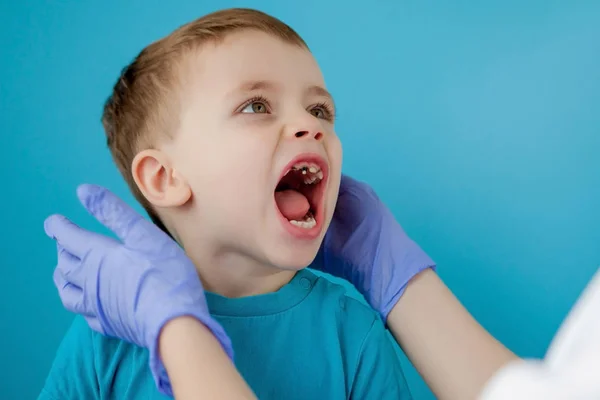 Klein schattig jongen poetsen zijn tanden op blauwe achtergrond — Stockfoto