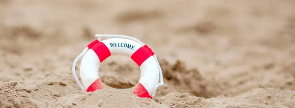 Primer plano de boya salvavidas en miniatura excavado en la arena en la playa — Foto de Stock