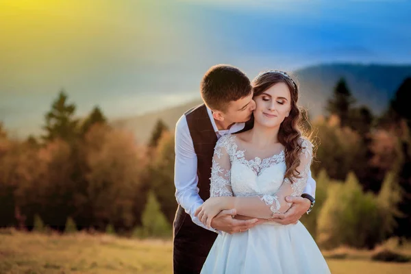 Braut und Bräutigam bei Sonnenuntergang romantisches Ehepaar — Stockfoto