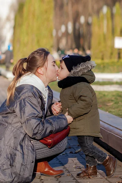 Menino feliz beijando a mãe ao ar livre. Dia das mães — Fotografia de Stock