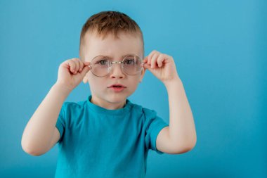 Mavi arka planı olan şirin bir çocuk. Çocuk harfleri öğreniyor. Alfabe