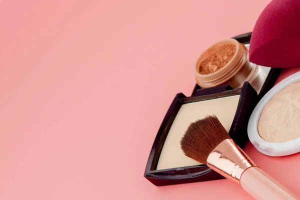 Set van kleurrijke cosmetica op roze houten ondergrond, basis voor make-up in de vorm van een kussen. Kopieerruimte — Stockfoto