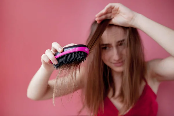 Νεαρό όμορφο κορίτσι έχει προβλήματα, ενώ τα μαλλιά σε ροζ φόντο — Φωτογραφία Αρχείου