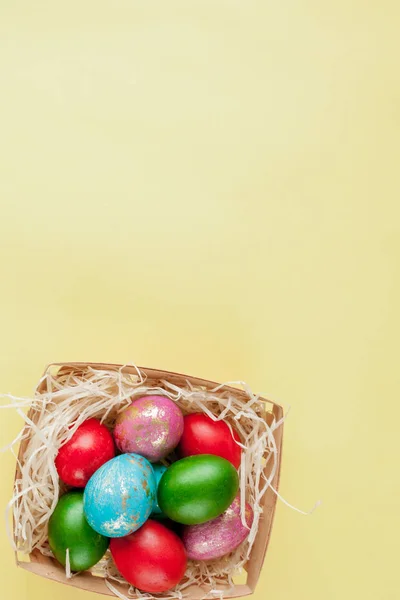 Glad påsk ägg gul bakgrund. Gyllene glans dekorerade ägg i korg, för gratulationskort, befordran, affisch. Kopiera utrymme — Stockfoto