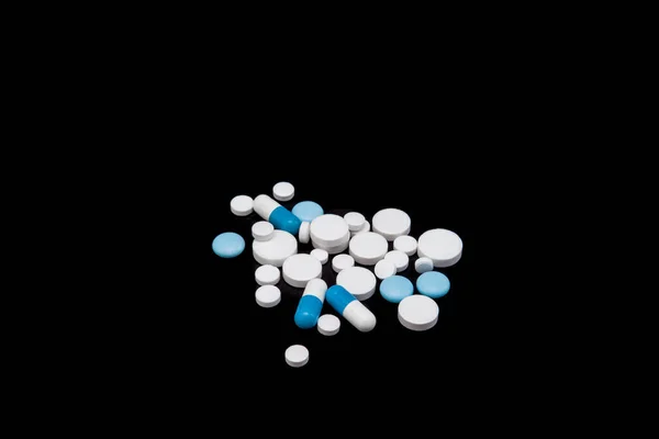 Pillole e capsule su sfondo nero. Medicinali e integratori alimentari — Foto Stock