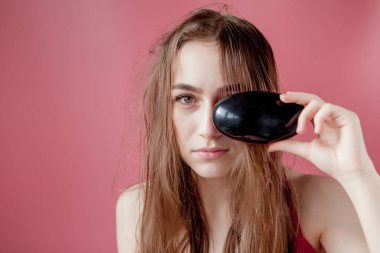 Pembe arka planda saçları olan genç ve güzel bir kız.