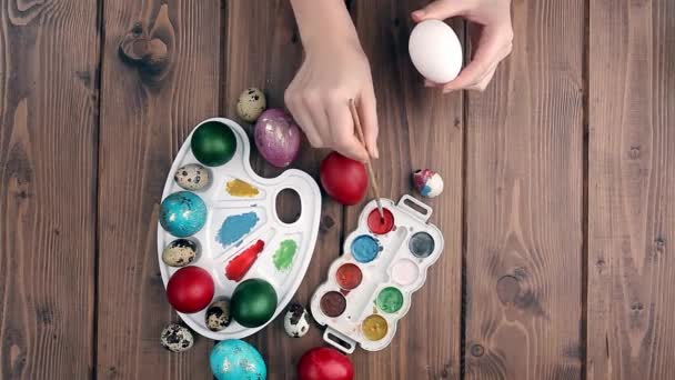 手は木製の背景にイースターの卵 塗料やブラシを描いた 休日の準備 女の子の手はパターンを描く — ストック動画