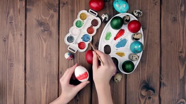 手は木製の背景にイースターの卵 塗料やブラシを描いた 休日の準備 女の子の手はパターンを描く — ストック動画