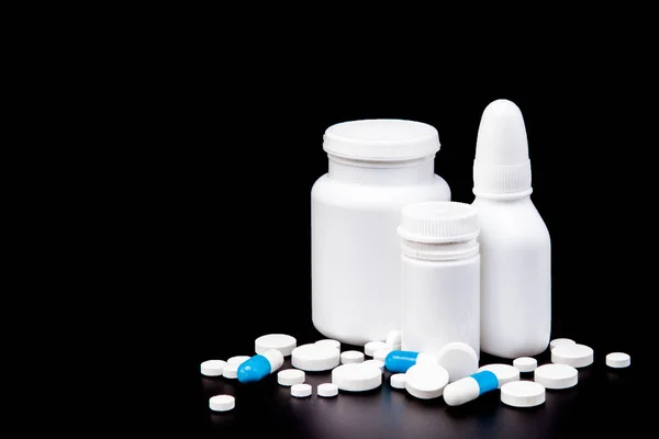 Garrafa com pílulas multi cor no fundo preto — Fotografia de Stock