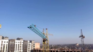 Yüksek binaların inşaatı ve inşaatı, çalışma ekipmanları ve işçileri olan inşaat endüstrisi. Yukarıdan bak, yukarıdan. Arkaplan ve doku